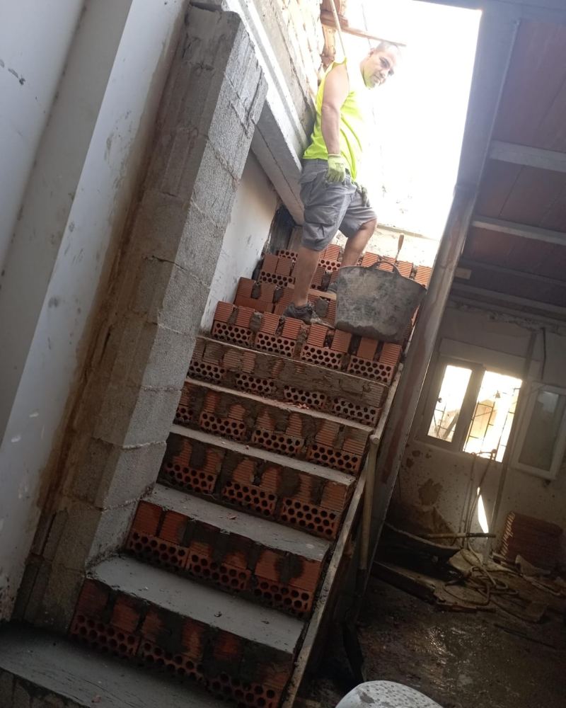 Albañil construyendo una escalera de obra