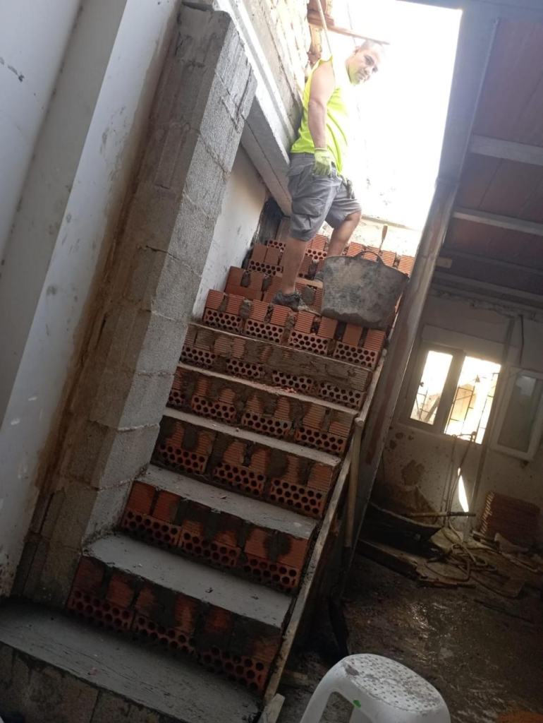 Albañil construyendo una escalera de obra con ladrillo