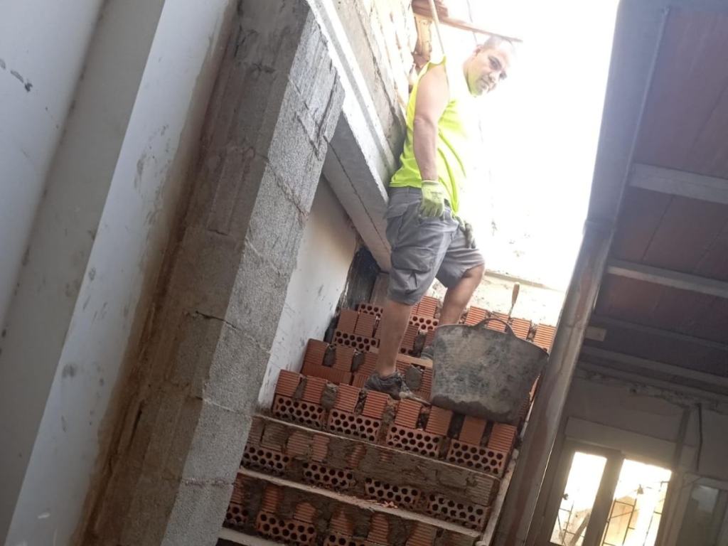 Albañil construyendo una escalera de obra