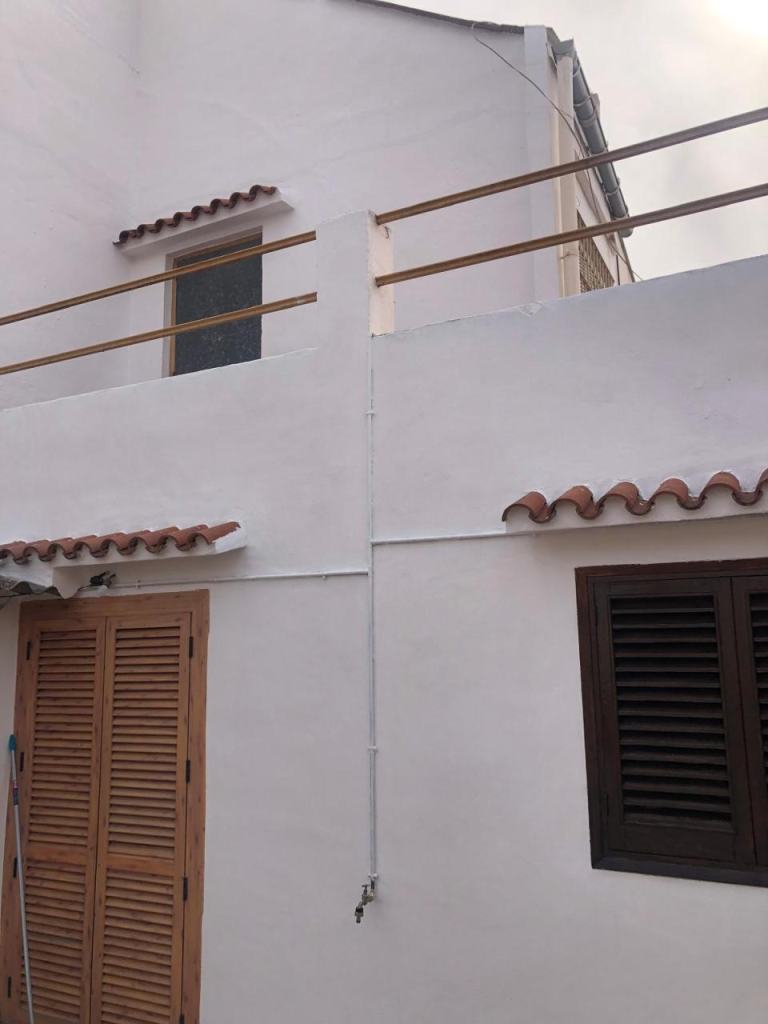 Fachada del patio pintada, con contraventanas de madera
